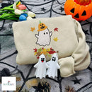 Beige embroidered sweatshirt featuring a cute white ghost wearing a pumpkin hat surrounded by colorful fall leaves.
