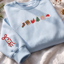 Light blue embroidered Christmas sweatshirt featuring holiday icons on the chest and a cute Santa Claus on the sleeve cuff.