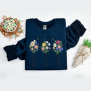 Navy blue sweatshirt with floral designs and text on a white background