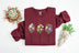 Light blue sweatshirt with floral designs and text on a white background