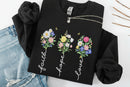 black sweatshirt with floral designs and text 'Faith', 'Hope', 'Love' on a white background.