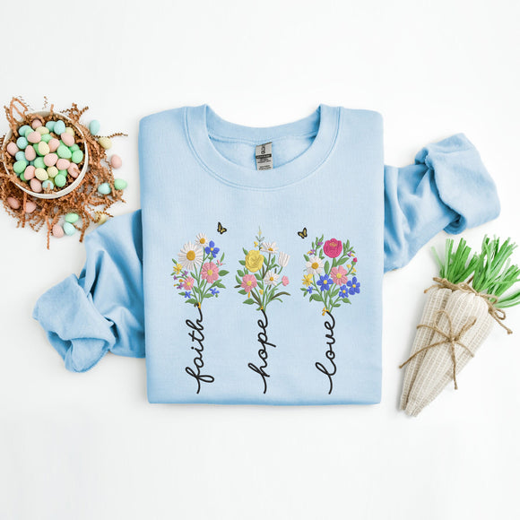 Light blue sweatshirt with floral designs and text on a white background