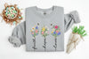 grey sweatshirt with floral designs and text on a white background