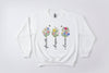 White sweatshirt with floral designs and text 'Faith', 'Hope', 'Love' on a white background.