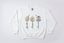 White sweatshirt with floral designs and text 'Faith', 'Hope', 'Love' on a white background.