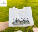 Four cute blue tabby kittens with funny vampire faces peeking out from orange Halloween pumpkins embroidered on apparel.