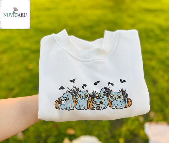 Four cute blue tabby kittens with funny vampire faces peeking out from orange Halloween pumpkins embroidered on apparel.